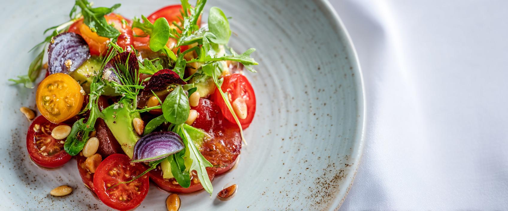 Avocado-tomatensalade met gepickelde sjalot, rucola en sherry-dragonvinaigrette