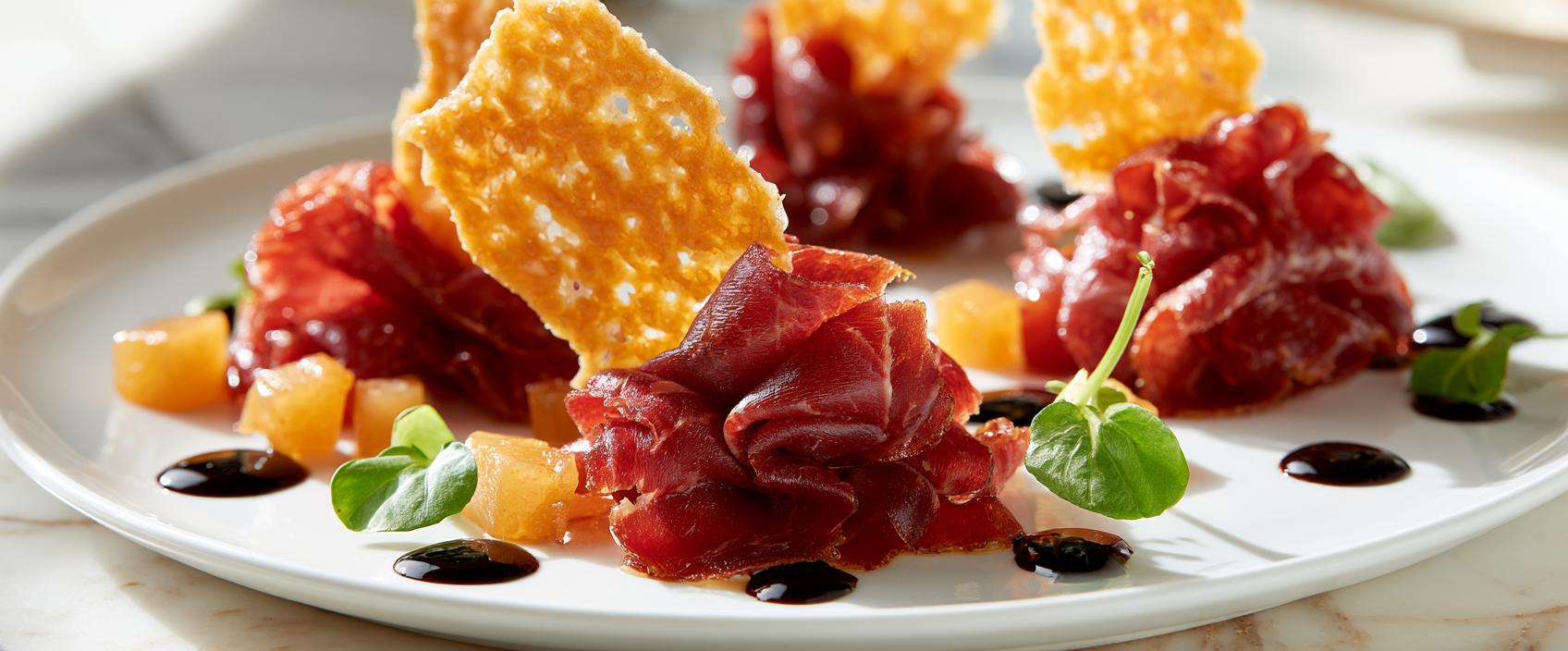 Cecina de León met geconfijte Pedro Ximénez-peer en Manchego-tuile