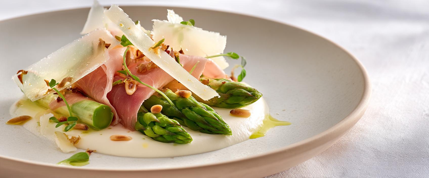 Lauwwarme aspergesalade met artisjokdressing, krokante parmaham en Parmigiano Reggiano