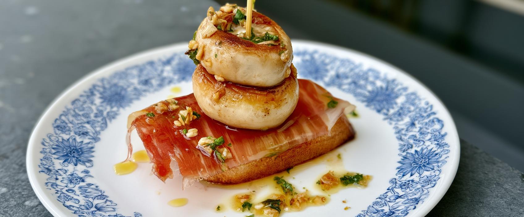 Pintxo van knoflookchampignons met ibéricoham en gekaramelliseerde druif