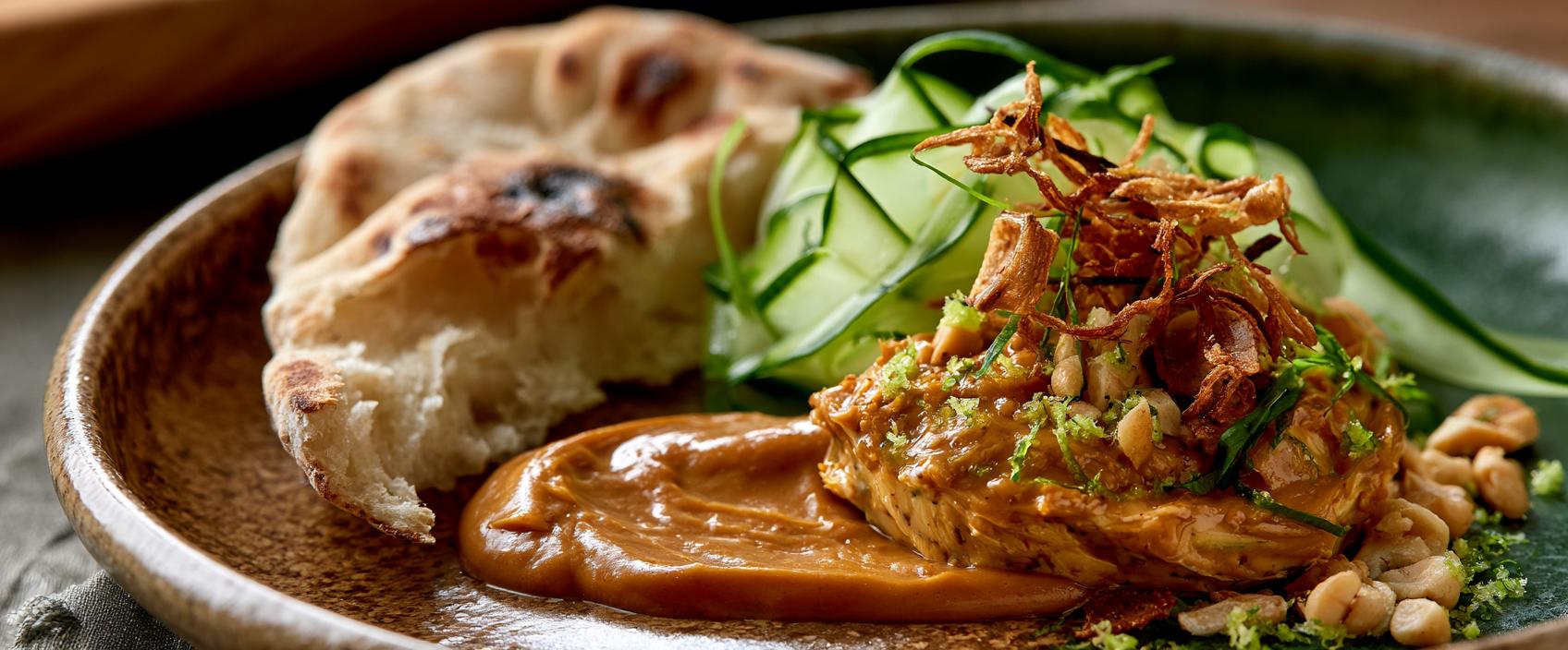 Saté-Boter met Warm Platbrood, Komkommerzuur en Krokante Uitjes