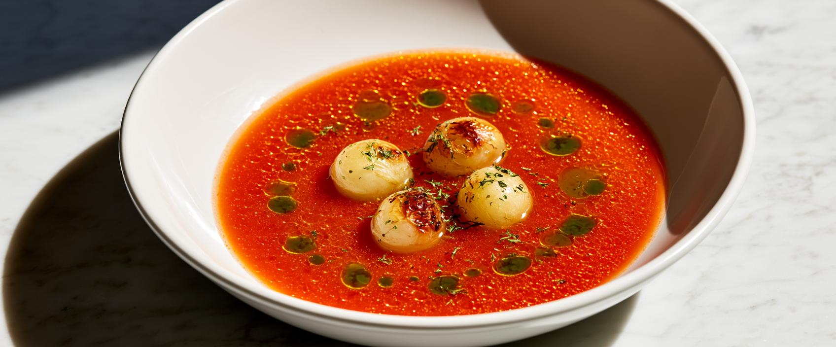 Tomatenbouillon met geroosterde witte druif en basilicum